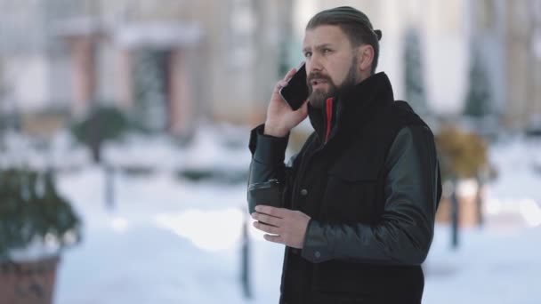 Hombre teniendo charla móvil en la calle nevada — Vídeos de Stock