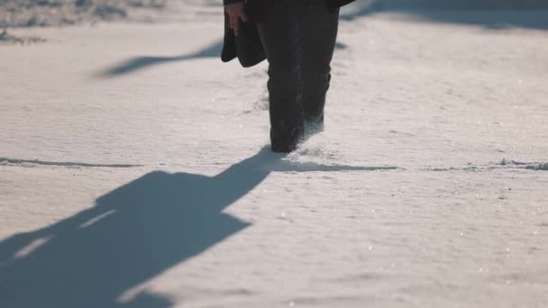 Primer plano de las piernas masculinas en zapatos de invierno pisando la nieve — Vídeos de Stock