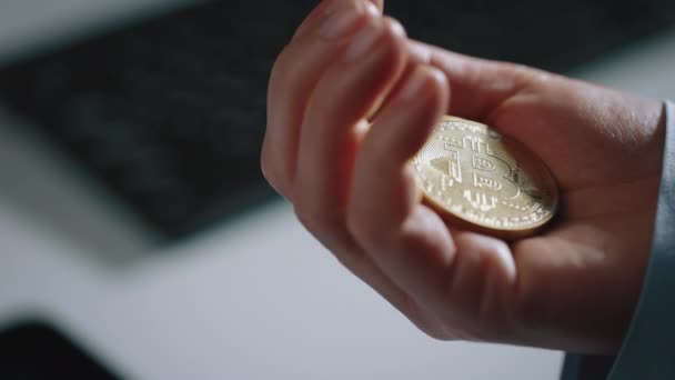 Flera gyllene bitcoins ligger i manlig hand — Stockvideo