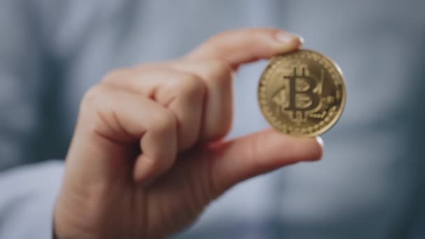 Närbild av man som visar fysiska bitcoin — Stockvideo