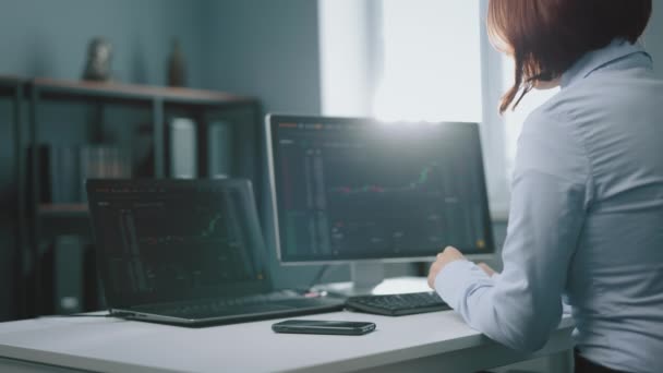 Mujer que usa computadoras para trabajar con el mercado de valores — Vídeos de Stock
