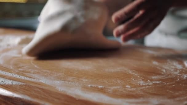 Fabricante de pizza amasando masa sobre mesa de madera — Vídeos de Stock