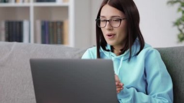 Gözlüklü kadın görüntülü sohbet için laptop kullanıyor