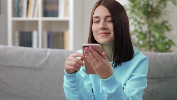 Hübsche Frau nutzt Smartphone zu Hause — Stockvideo