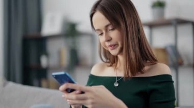 Kanepede dinlenen ve akıllı telefon kullanan bir kadın.