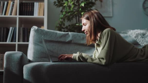 Jovem mulher digitando no laptop em casa — Vídeo de Stock