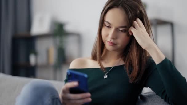 Kvinna vilar på soffan och använder mobil — Stockvideo