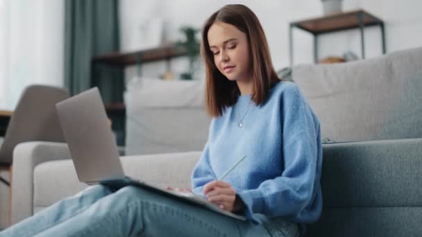 Mujer tomando notas durante el chat de vídeo en el ordenador portátil — Vídeo de stock