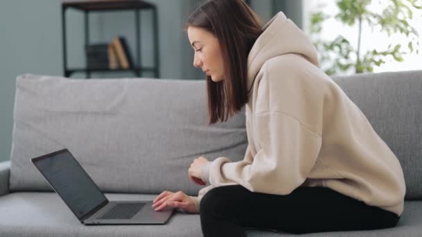 Frau benutzt Laptop auf Sofa — Stockvideo