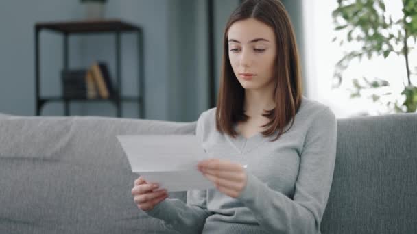 Mujer leyendo carta en sofá — Vídeo de stock