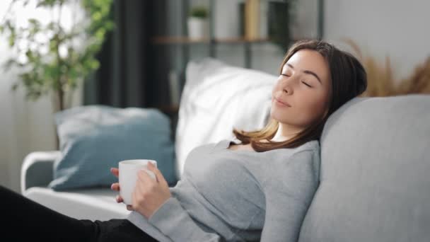 Glückliche Frau entspannt auf dem Sofa — Stockvideo