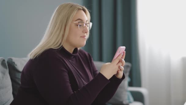 Blonde en surpoids à l'aide d'un smartphone — Video