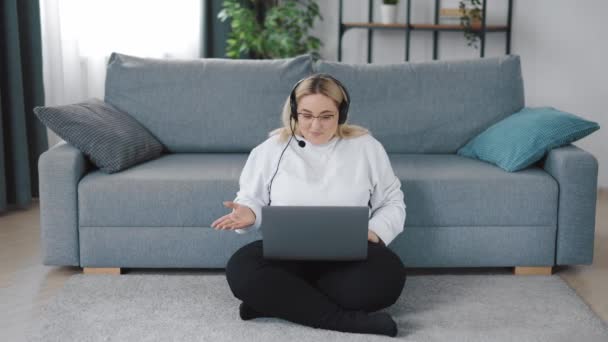 Mujer con auriculares usando laptop — Vídeo de stock