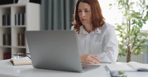Uitgeputte vrouw werken op laptop — Stockvideo