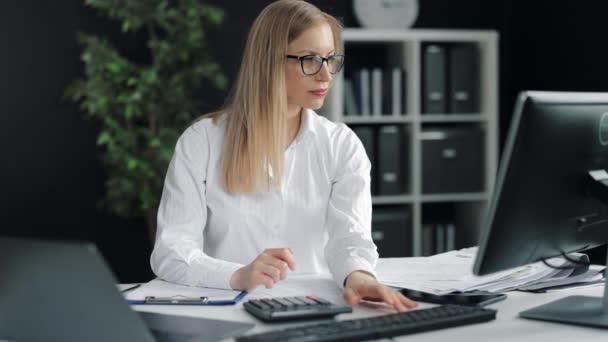 Femme calculant les factures au bureau — Video