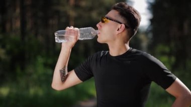 Sporcu koşudan sonra su içiyor