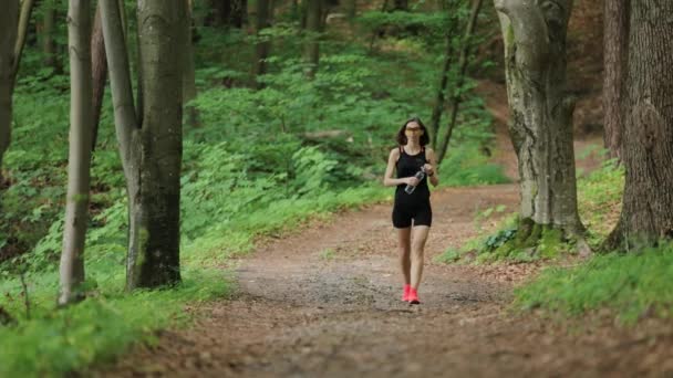 Жінка біжить і п'є воду — стокове відео