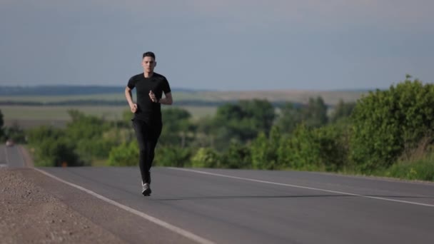 Manlig idrottsman som springer på väg — Stockvideo