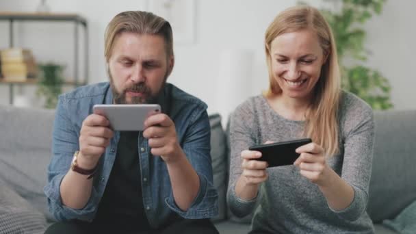 Paar spelletjes spelen op smartphones — Stockvideo