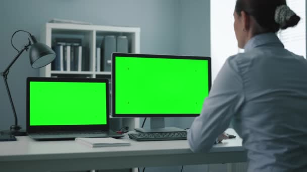 Mulher usando dois computadores verdes — Vídeo de Stock