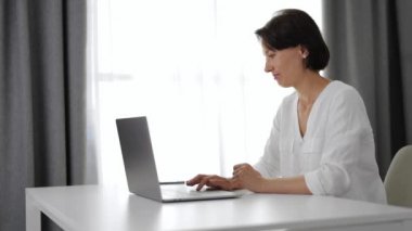 Evde Dizüstü bilgisayar kullanan kadın