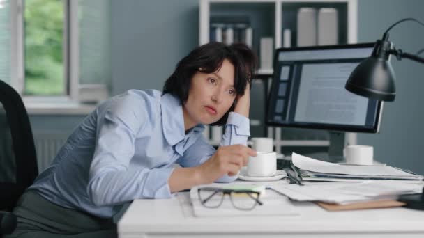 Виснажена жінка сидить в офісі — стокове відео