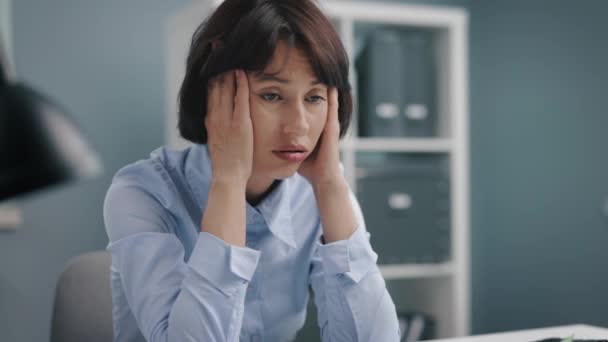 Traurige Frau sitzt im Büro — Stockvideo