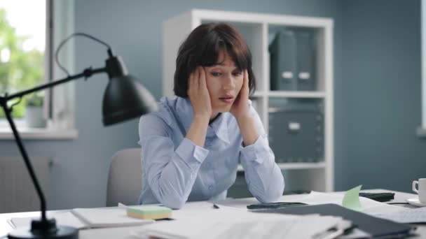Överarbetad kvinna som sitter på kontoret — Stockvideo