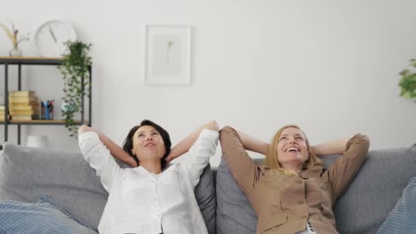 Två kvinnor kopplar av på soffan — Stockvideo