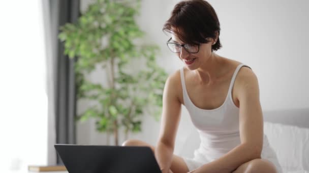 Nő dolgozik laptop az ágyban — Stock videók