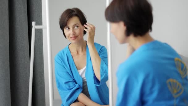 Задоволена жінка дивиться на дзеркало — стокове відео