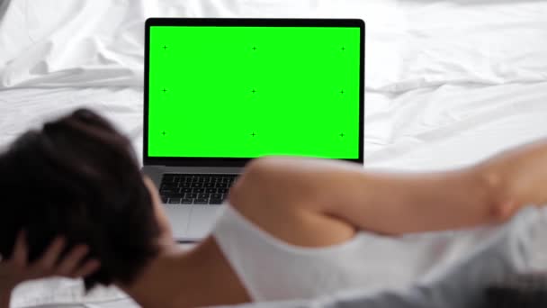 Laptop zöld képernyővel az ágyon — Stock videók