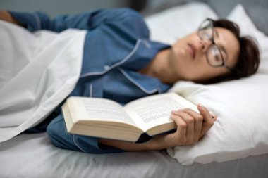 Kadın kitapla uykuya daldı.