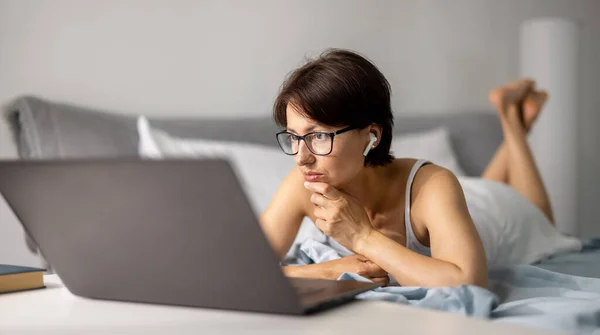 Mujer usando portátil en la cama — Foto de Stock