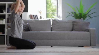 Evde yoga yapan bir kadın.
