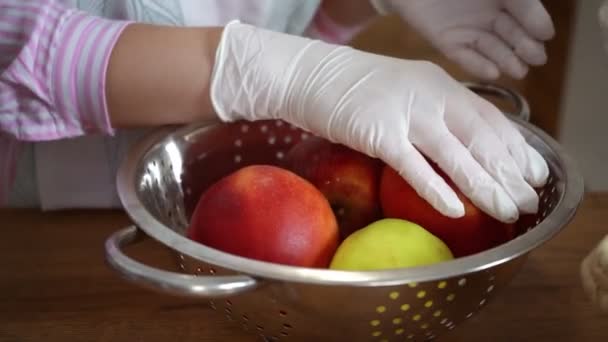 Женщины кладут яблоки в дуршлаг — стоковое видео