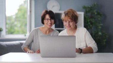 Kadınlar sohbet için dizüstü bilgisayar kullanıyor