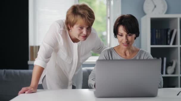 Dos mujeres usando el ordenador portátil — Vídeos de Stock