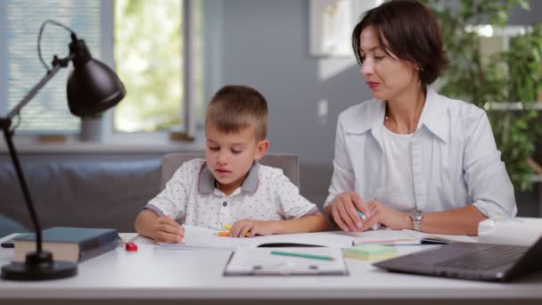 Мати допомагає синові з домашнім завданням — стокове відео