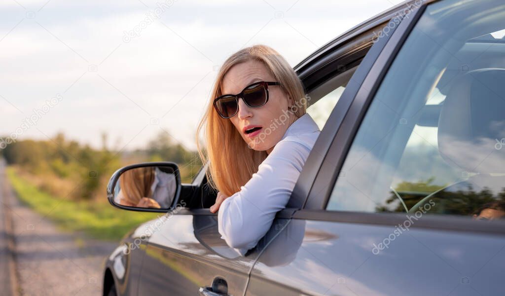 Shocked woman in car outdoors