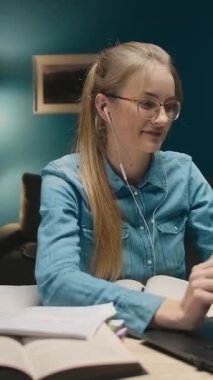 Uzun saçlı bir kadın, sıcak, karanlık bir odada çalışıyor. Kulaklık takıyor ve işine konsantre olurken etrafını kitap ve notlarla çevrili bir dizüstü bilgisayarda yazıyor..