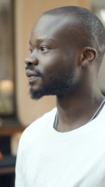 Siyah sakallı neşeli bir adam evin içinde çekilmiş bir portrede sıcak bir şekilde gülümsüyor. Kişiliğini ve tarzını gösteriyor..