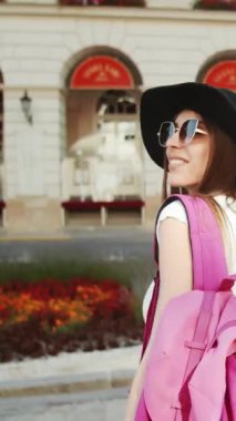 Şık bir şapka takan bir gezgin güzel bir yerde canlı manzaranın tadını çıkarır, neşe saçar..