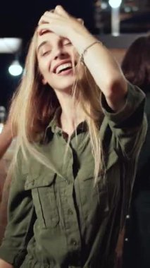 İnsanlar parlak ışıklarla ve neşeli müziklerle dolu canlı bir dans partisinin tadını çıkarıyor.