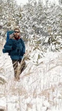 Bir gezgin kış manzarasını keşfederken karlı bir ormanın güzelliğini keşfedin.