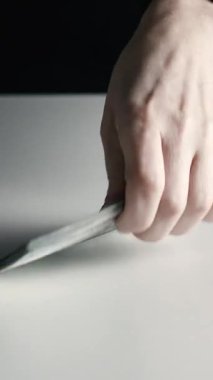 Eller, banknotları odaklanmış bir şekilde masaya dizer ve yığar.