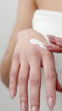 Eller, dokuyu ve hareketi göstermek için cilde farklı açılardan krem sürerler.