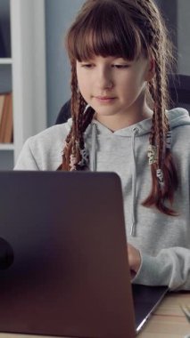 Kız evde dizüstü bilgisayar eğitimi görüyor. Odaklanmış iş.