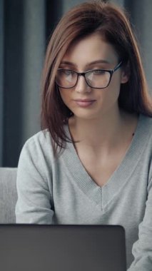 Kadın gün içinde evde çalışmak için dizüstü bilgisayar kullanıyor..