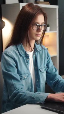 Kadınlar akşam evde otururken dizüstü bilgisayarda yazarlar..